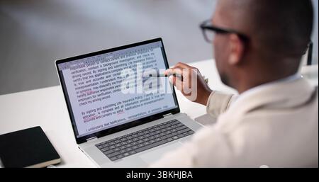 Document Proofreading: African American Man Editing Script Online Spelling Errors Stock Photo