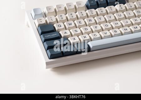 Modern mechanical keyboard on white background. Minimal style and design keyboard. Custom build keyboard. Colorful key blue and white cap. Close up. Stock Photo