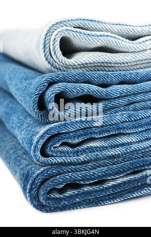 Pile of folded textiles, various shades of blue jeans fabric, denim cloth, are stacked on top of each other in store setting, showcasing different tex Stock Photo