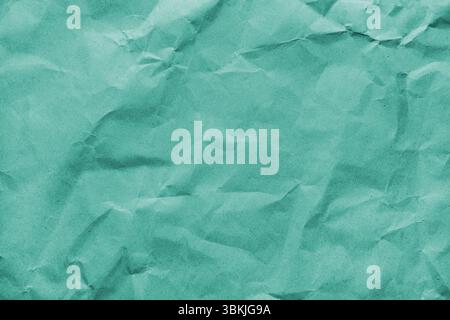 Recycled crumpled turquoise colored paper texture. Wrinkled craft paper background, rough cardboard surface, wallpaper, backdrop. Design element, copy Stock Photo