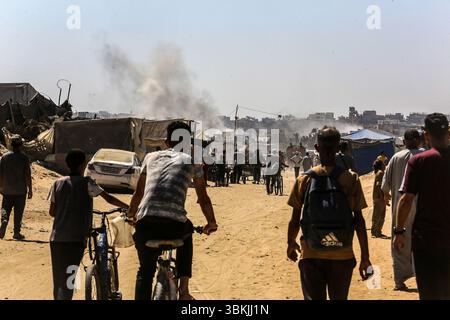 Khan Younis, Gaza. 20th June, 2025. Palestinians watch as smoke rises above tents of displaced people after an Israeli strike in Khan Younis, a city in the southern Gaza strip, on Saturday, June 21, 2025. Photo by Anas Deeb/UPI Credit: UPI/Alamy Live News Stock Photo