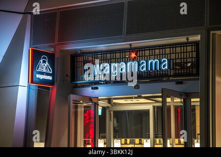 London, UK - September 14, 2023: Wagamama exterior logo, a popular British chain of pan asian restaurants based on Japanese food at night. Stock Photo
