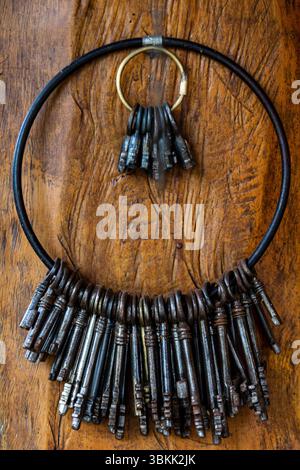 Bunch of old keys hanging on wooden textured wall Stock Photo