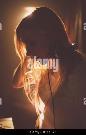 Side view of young woman in music studio Stock Photo