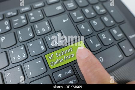 Submit online form key on a gray keyboard. Finger pressing key Stock Photo