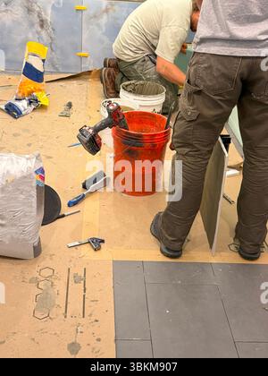 Two construction workers focus on details while working on a renovation project. Stock Photo