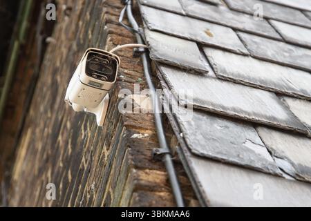 A CCTV security camera is mounted on the side wall of a residential house, highlighting home surveillance and modern safety measures in an urban setti Stock Photo
