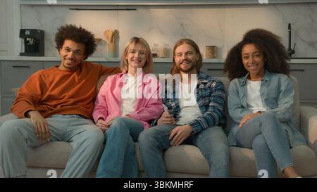 Multiracial group of friends multiethnic diversity people men Caucasian guys buddies African American girl women relaxing together at home couch sofa Stock Photo