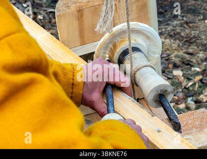 Making a wooden bowl with a hand chisel on an old machine Stock Photo