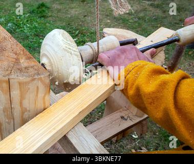 Making a wooden bowl on a reconstructed medieval lathe Stock Photo