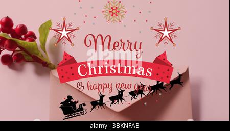 Displaying pink envelope on pink backdrop, showing Christmas banner with holly and Santa sleigh Stock Photo