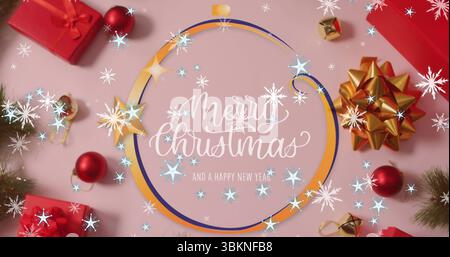 Showcasing frame with holiday text on pink tabletop, with red gift boxes, baubles, gold bow Stock Photo