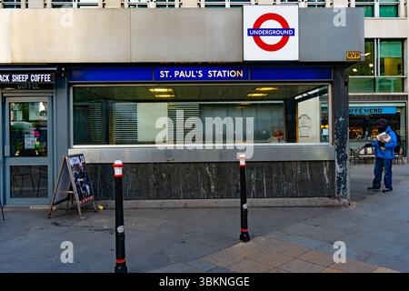 A newspaper distributor at St Paul's Underground Station in London in the early morning Stock Photo