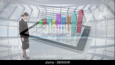 Standing businesswoman observing tablet displaying 3D bar chart in modern atrium, copy space Stock Photo