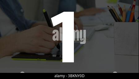 Drawing designer using tablet stylus with colleague typing keyboard at studio desk colored pencils Stock Photo