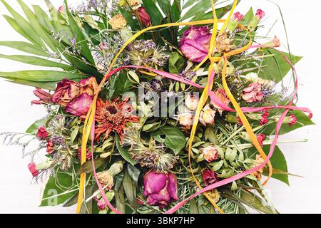 Colorful dried flower bouquet on white background. Decorative floral arrangement with natural textures. Rustic aesthetic for home decor. Stock Photo