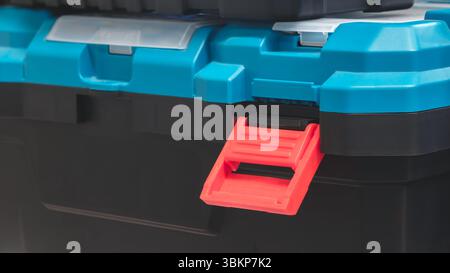 Black Plastic Tool Box with Blue Lid with Open Red Lock Stock Photo