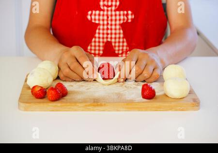 Homemade strawberry dumplings preparation with curd cheese dough on wooden board, traditional Czech sweet dish, known as jahodove knedliky Stock Photo
