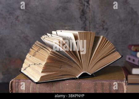 Open dictionary, hardcover, lying on books, close-up Stock Photo
