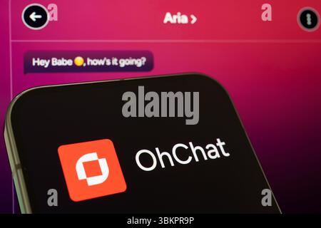 OhChat platform logo shown on smartphone with chat screen in background, showcasing AI-powered conversation tool for adult digital interaction. Staffo Stock Photo