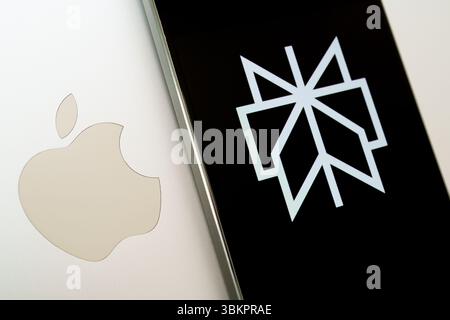Perplexity logo on smartphone next to Apple logo on laptop. Stock Photo