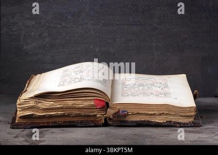 An open old leather-bound book on a dark background Stock Photo
