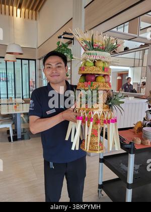 Smiling young waiter presenting a beautiful fruit arrangement, Harris Hotel, Denpasar, Bali, Indonesia Stock Photo