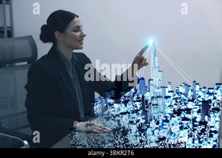 Building information modelling. Woman using holographic projection of city in office Stock Photo