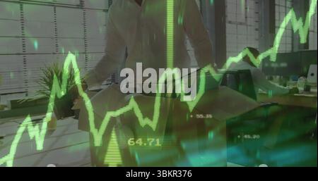 Leaning man in white shirt adjusting architectural model at office, with financial chart overlay Stock Photo