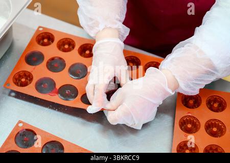 Creating marmalade pieces using silicone molds in a clean kitchen environment during a culinary workshop Stock Photo