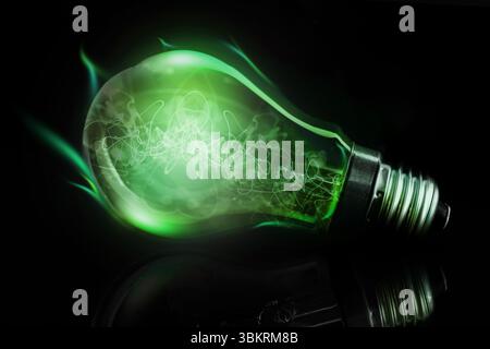 3D render glowing green bulb is lying horizontally on dark glossy surface, casting faint reflection Stock Photo