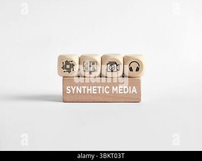 Four wooden cubes with media icons on top of a wooden block with the text synthetic media representing the creation process Stock Photo