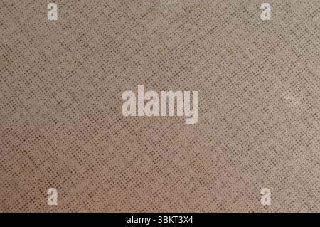 Light brown perforated or textured metal surface background with grid pattern. Stock Photo