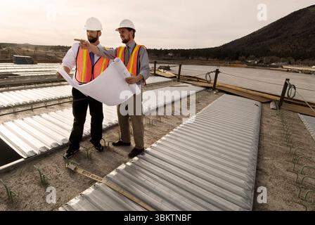 Two engineers survey the progress of a freeway overpass during a break in construction, Flagstaff, Arizona. Stock Photo