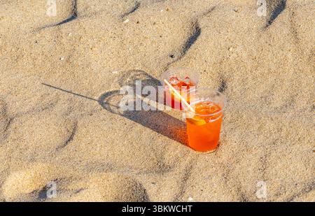 two ice cold alcoholic beverages in the sand on a montauk ocean beach Stock Photo