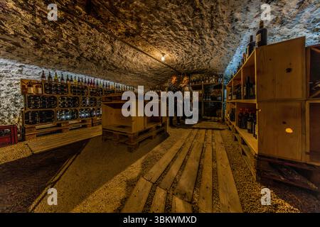 Self-service wine cellar at the Auberge restaurant Chez Cul de Paille in Poitiers. Guests go to the cellar room and choose a bottle of wine to accompany their meal. Prices are displayed on the wine boxes. Guests take the bottle to their table themselves, where it is opened by the staff. One of the special features of the Auberge Le Cul de Paille is that guests can choose their own table wine in the cellar and that many famous artists, such as Jaques Brel, have immortalised themselves on the walls with autographs, sayings and drawings. Rue Théophraste Renaudot, Poitiers, Nouvelle-Aquitaine, Fra Stock Photo