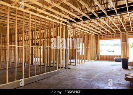 Wooden framing structure is taking shape inside building, revealing an open layout under natural light at site. Stock Photo