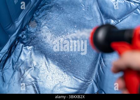 Bavaria, Germany - June 23, 2025: A man fills an inflatable whirlpool in the garden with water, perfect for cooling off on warm summer days and relaxing hours in your own outdoor area *** Ein Mann befüllt einen aufblasbaren Whirlpool im Garten mit Wasser, perfekte Abkühlung an warmen Sommertagen und entspannte Stunden im eigenen Outdoor Bereich Stock Photo