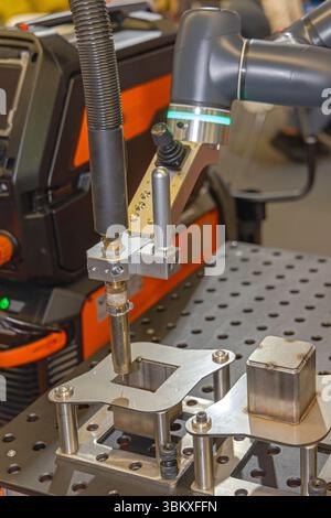 Automated Robot Arm Torch Welding Metal Parts in Factory Production Stock Photo