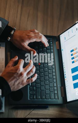 A business person works late, analyzing data on their laptop, demonstrating diligence and productivity. Stock Photo