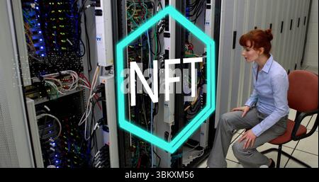 Sitting IT tech managing cables near server racks in server room, with NFT overlay, copy space Stock Photo