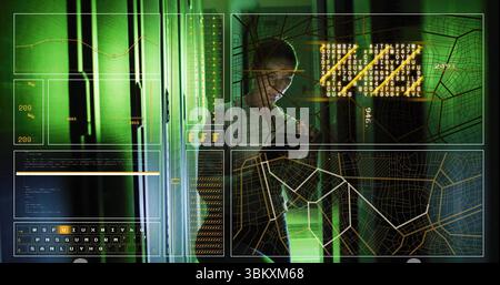 Analyzing woman in white shirt using handheld device in green server room, with racks, code panels Stock Photo
