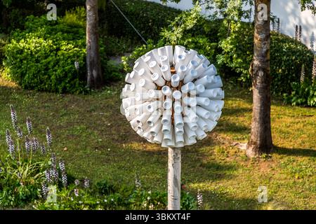 A kinetic windmill installation made up of white plastic cylinders mounted on a wooden pole in the grounds of Futuroscope. Such objects form part of the park’s overall design concept, which combines technology, nature and interactive art. The Futuroscope near Poitiers is an amusement park that specialises in futuristic themes, multimedia experiences and innovative attractions. Chasseneuil-du-Poitou, Nouvelle-Aquitaine, France Stock Photo