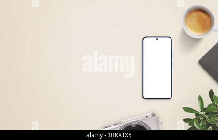 Smartphone mockup on beige desk with large empty space on left for promo text. Surrounded by coffee, camera, notebook, and plant Stock Photo