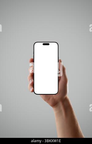 Realistic smartphone in male hand on gray background with dramatic lighting, perfect for showcasing premium app UI, tech products, or mobile concepts Stock Photo