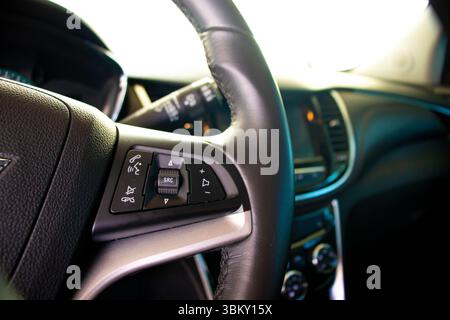 Close-up of car steering wheel with integrated audio and phone controls Stock Photo