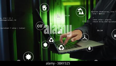 Korean man in jacket monitoring server racks in data center, with laptop, eco icons and JavaScript Stock Photo