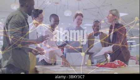 Group of six office professionals collaborating around table in office, with charts, sneakers Stock Photo