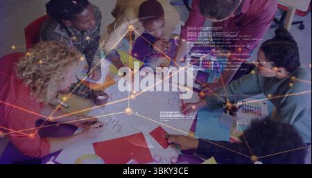 Collaborating team sketching ideas on paper in conference room, with color wheel and sticky notes Stock Photo