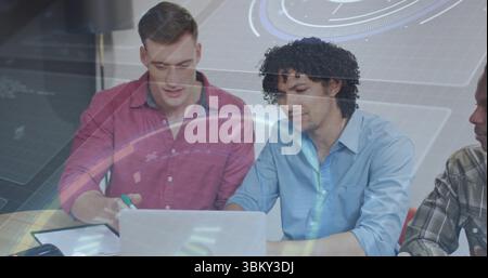 Collaborating coworkers wearing shirts and working on laptop at office table with notebook pen Stock Photo